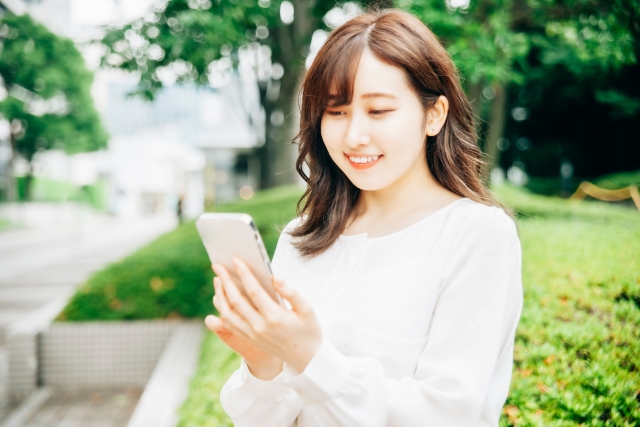 スマートフォンを見つめる女性の画像