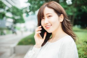 スマートフォンで会話する女性の画像